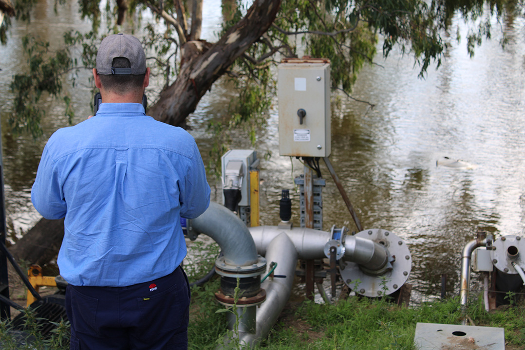 NRAR officer inspects a pump by the river
